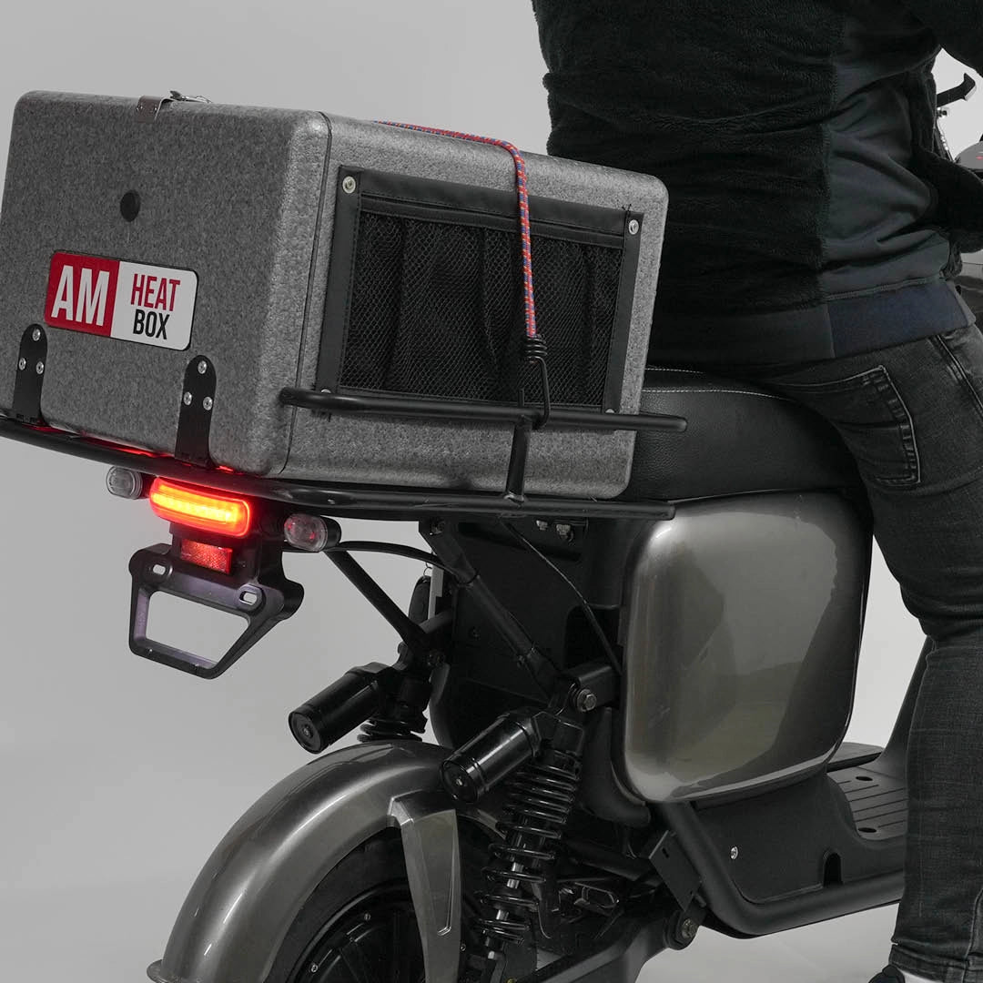 Person auf Roller mit elektrischer Wärmebox und sichtbarem Rücklicht – ideal für Lieferdienste